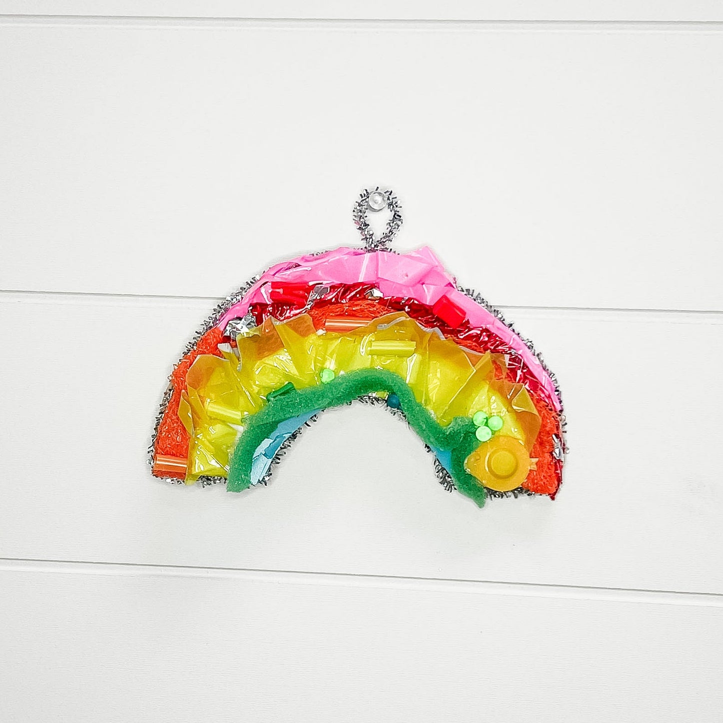 Colorful rainbow-shaped object on a white wooden surface