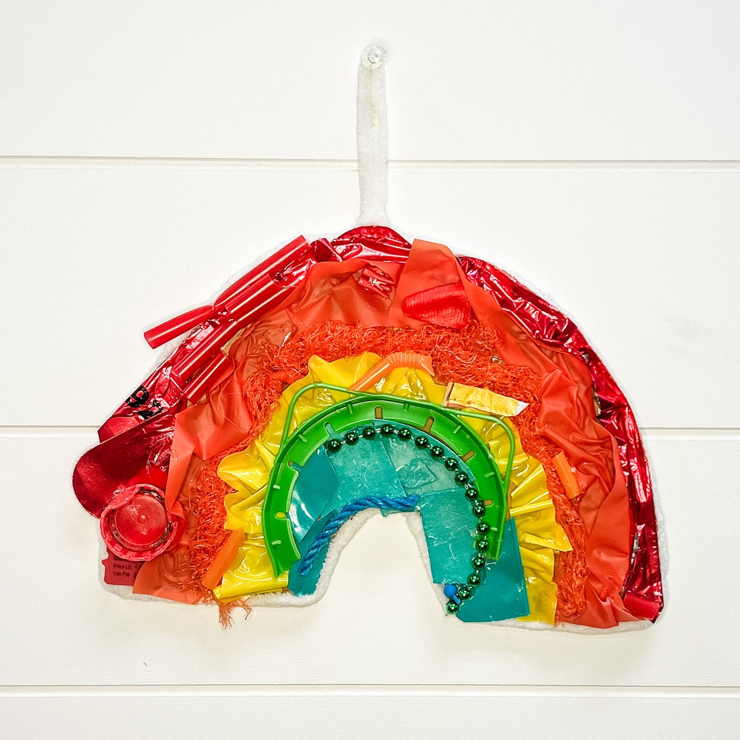 Colorful rainbow-shaped object on a white wooden background