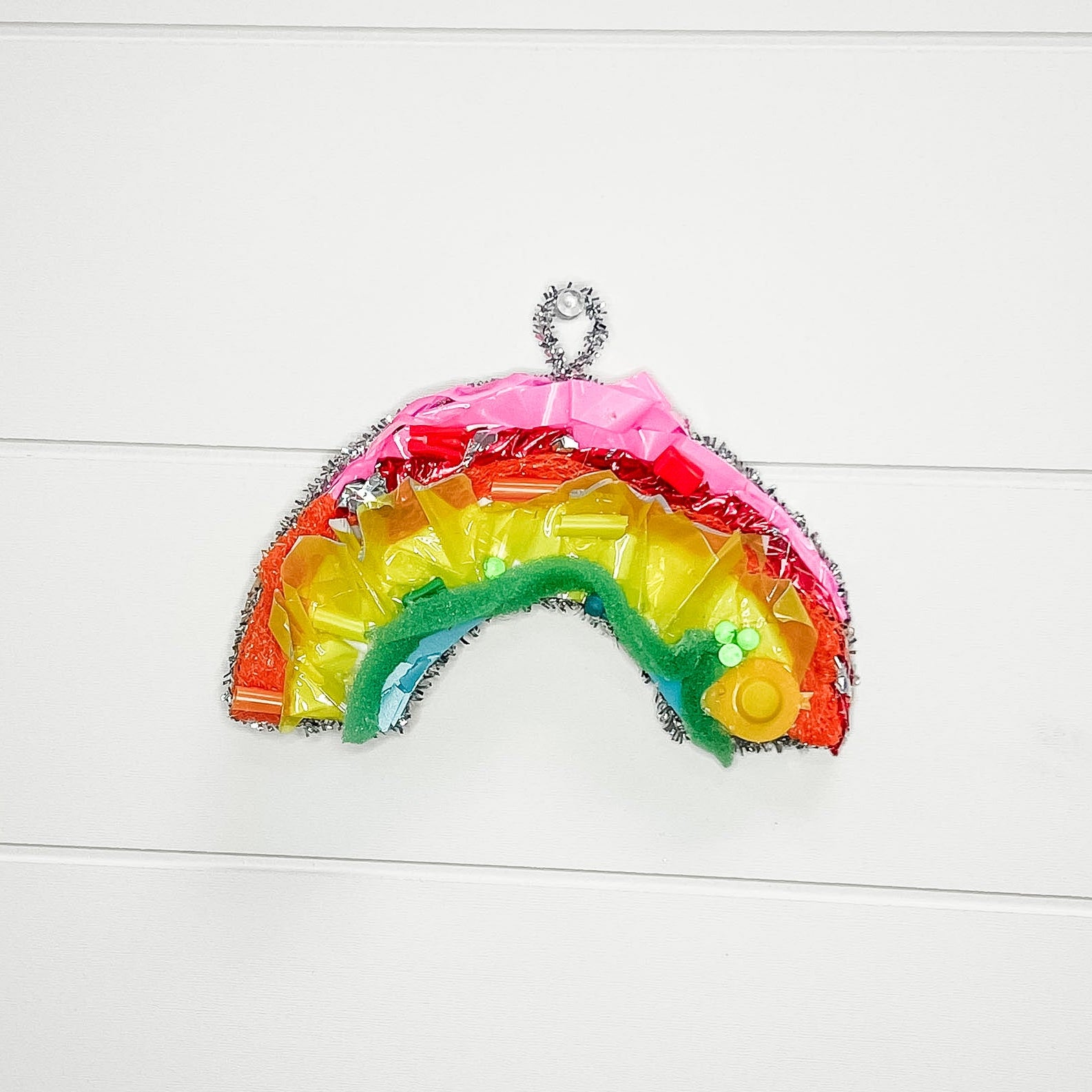 Colorful rainbow-shaped object on a white wooden surface