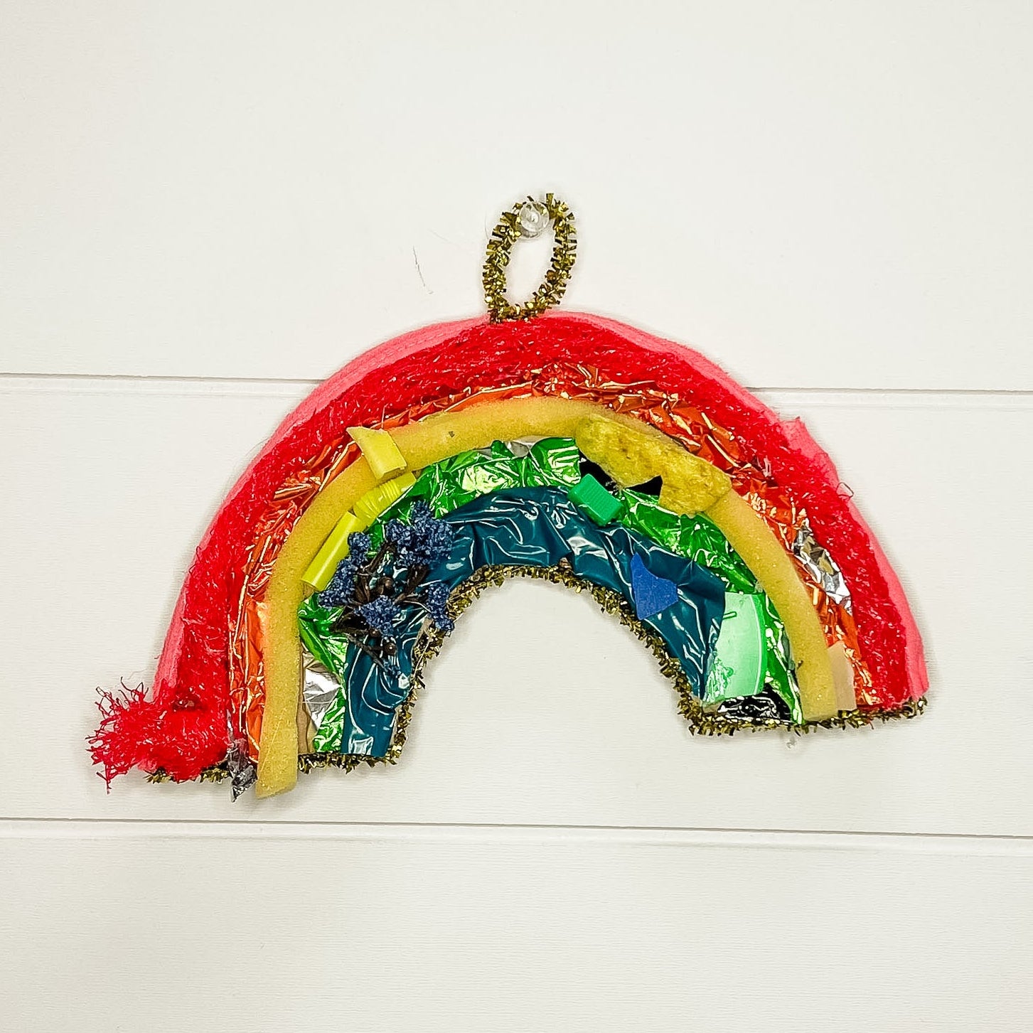 Colorful rainbow-shaped object on a white wooden background