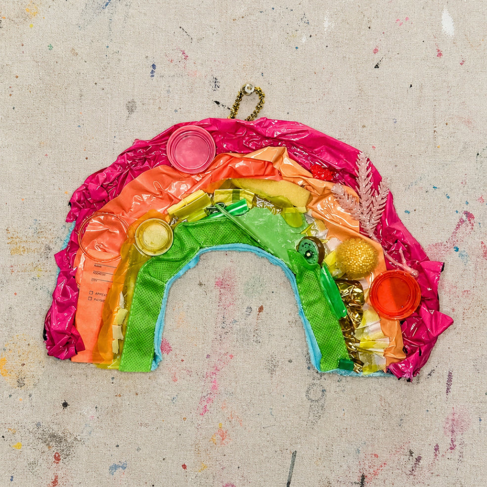 Artistic rainbow made of colorful plastic on a textured beige background