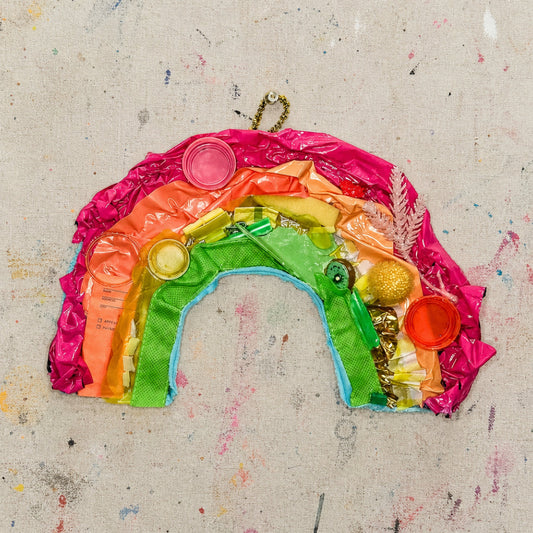 Artistic rainbow made of colorful plastic on a textured beige background