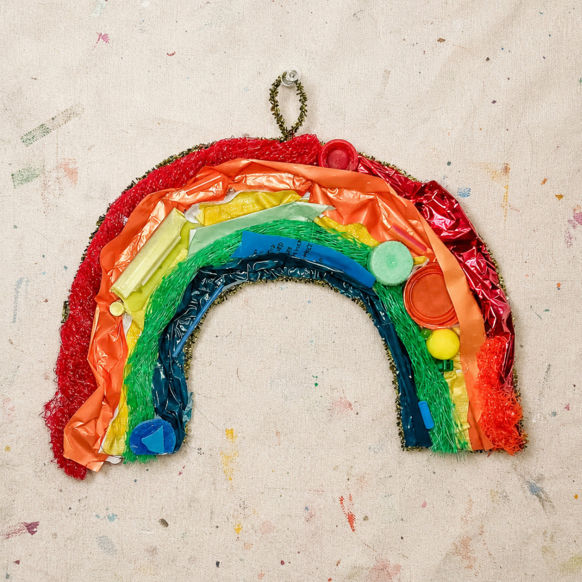Colorful rainbow-shaped craft on a textured beige background