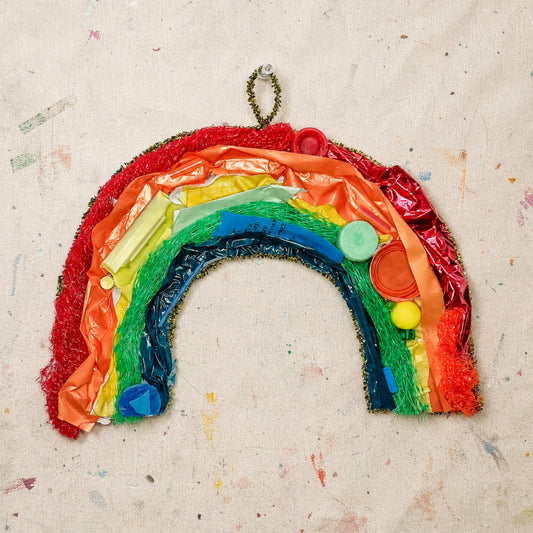 Colorful rainbow-shaped craft on a textured beige background